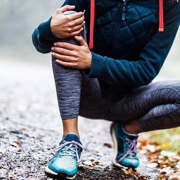 Joggerin in Hocke fasst sich ans Knie